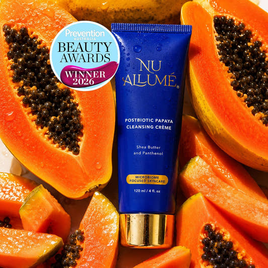 A blue tube of Nu Allume Postbiotic Papaya Cleansing Crème with a gold cap, surrounded by sliced papayas, with a Prevention Beauty Awards Winner 2026 badge overlay.