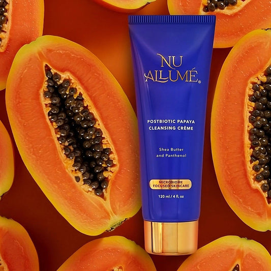 Tube of Nu Allume Postbiotic Papaya Cleansing Crème surrounded by halved papayas.