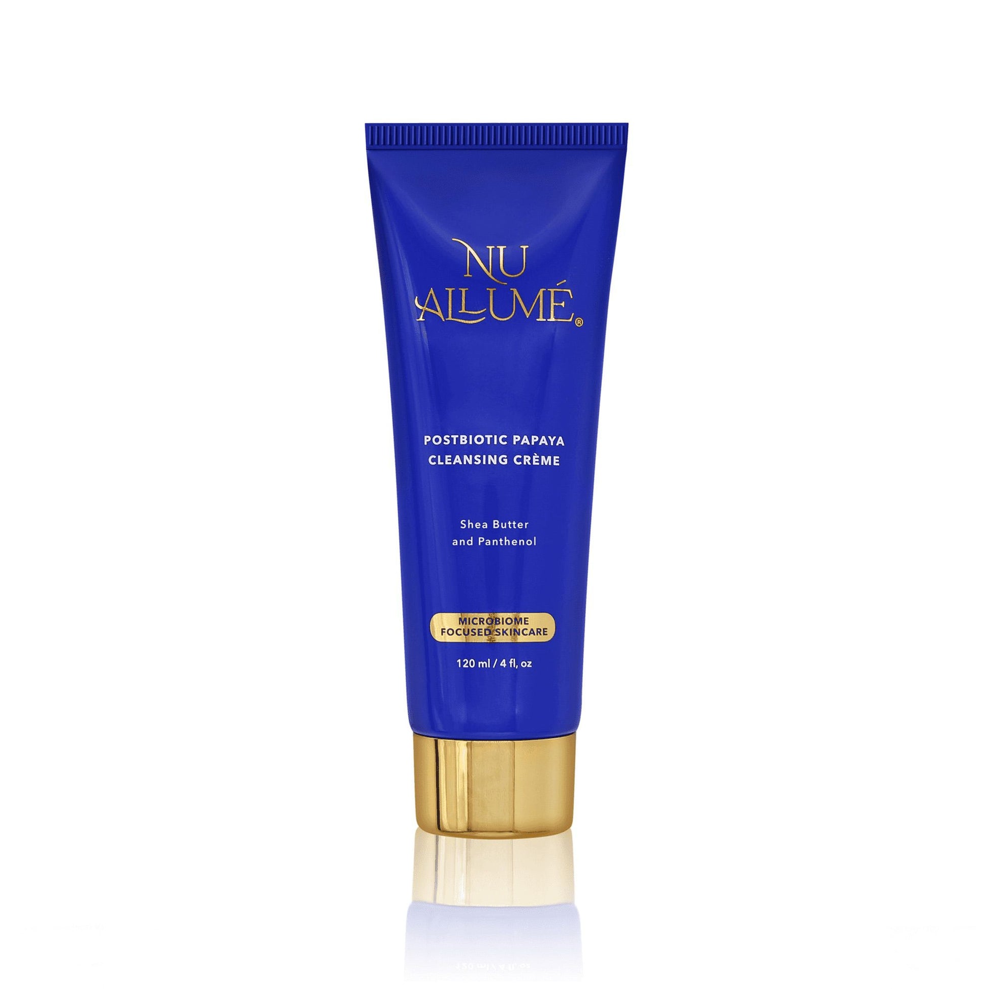 Tube of Nu Allume Postbiotic Papaya Cleansing Crème with gold cap and reflecting below off a white shiny surface