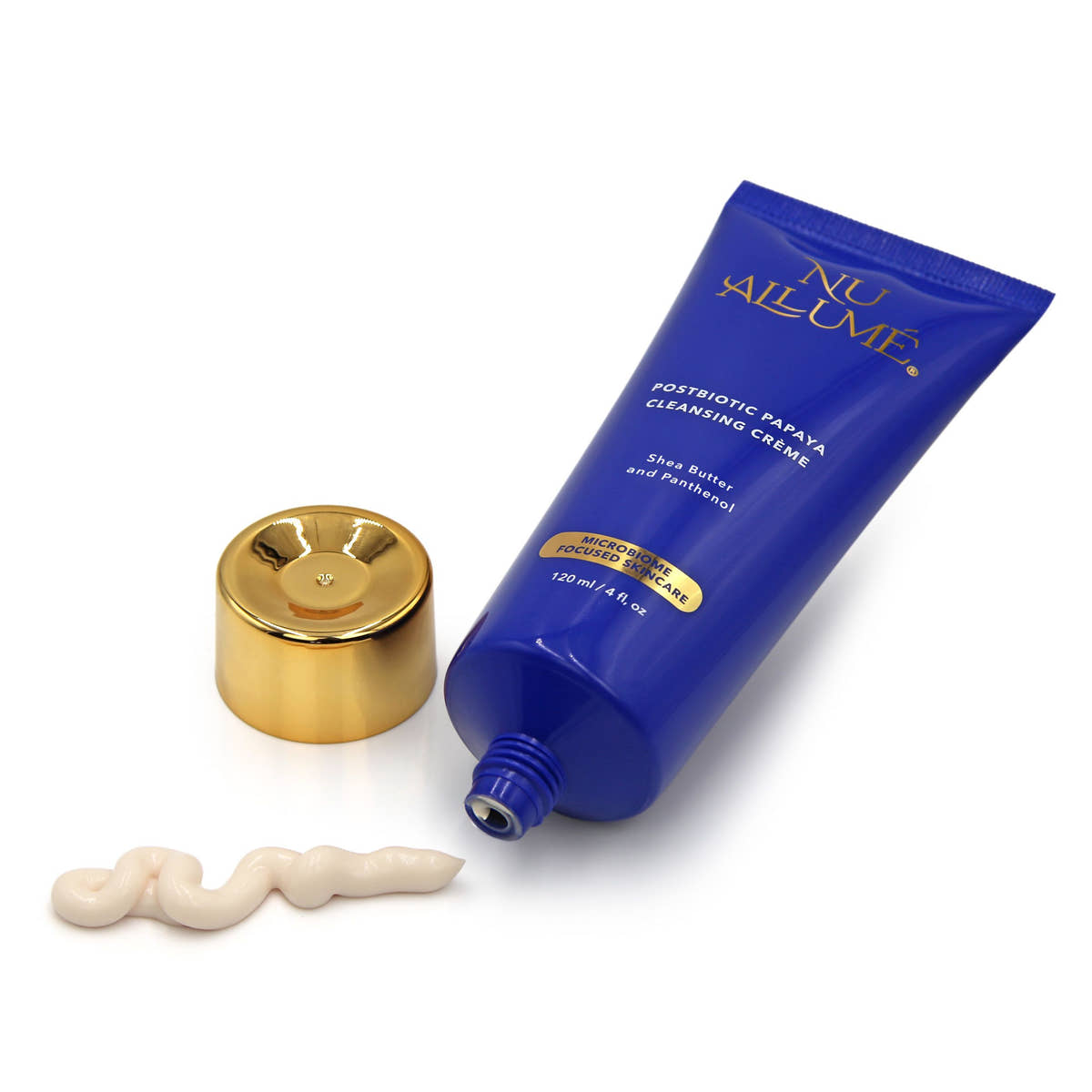 Tube of Nu Allume Postbiotic Papaya cleansing crème with gold cap and slightly peach coloured cream on a white background
