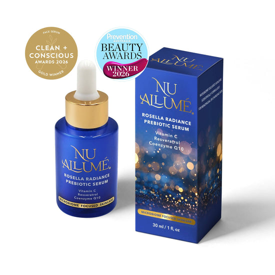 Nu Allumé Rosella Radiance Prebiotic Serum in a blue dropper bottle with a gold collar, shown next to its blue packaging box. Two award badges are displayed in the top left corner on a clean white background. Clean and Conscious Awards Gold Winner 2026 and Prevention Beauty Awards Winner 2026.